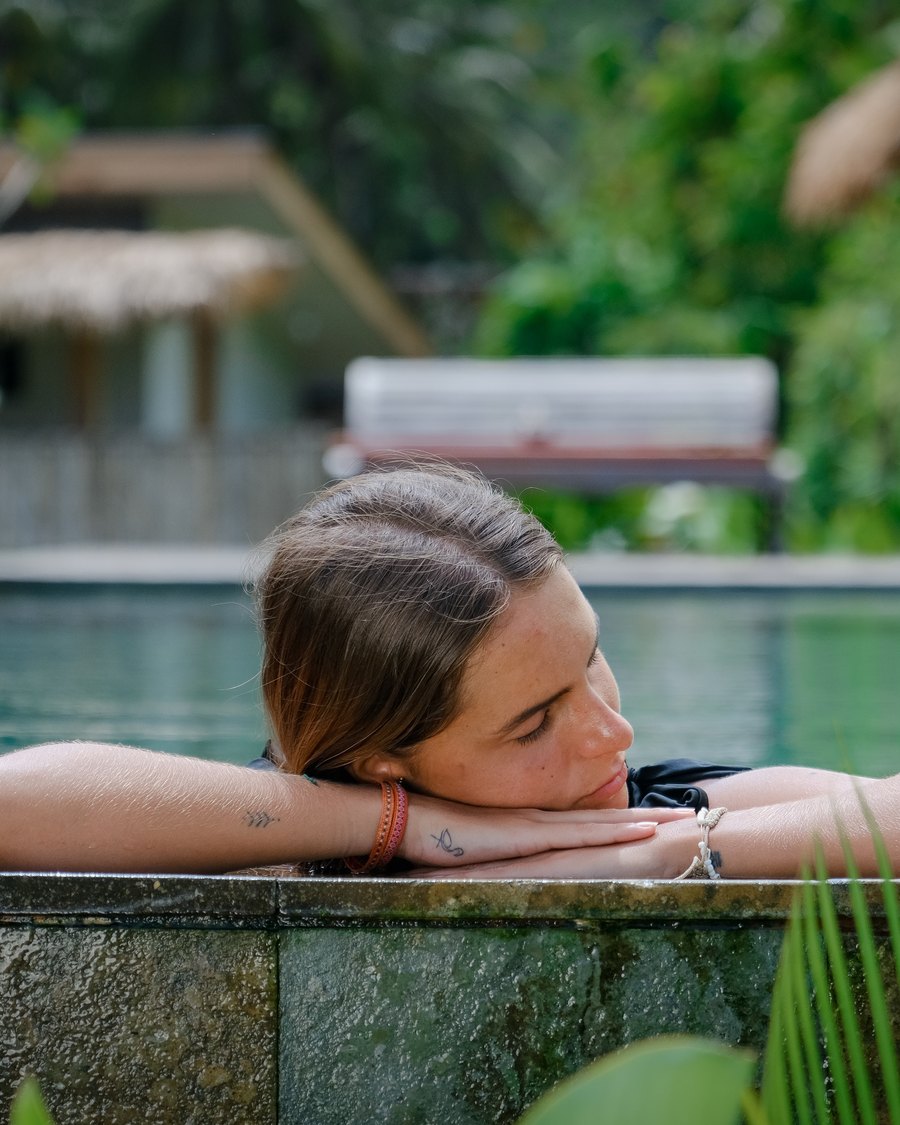a woman resting her head on the edge of the pool